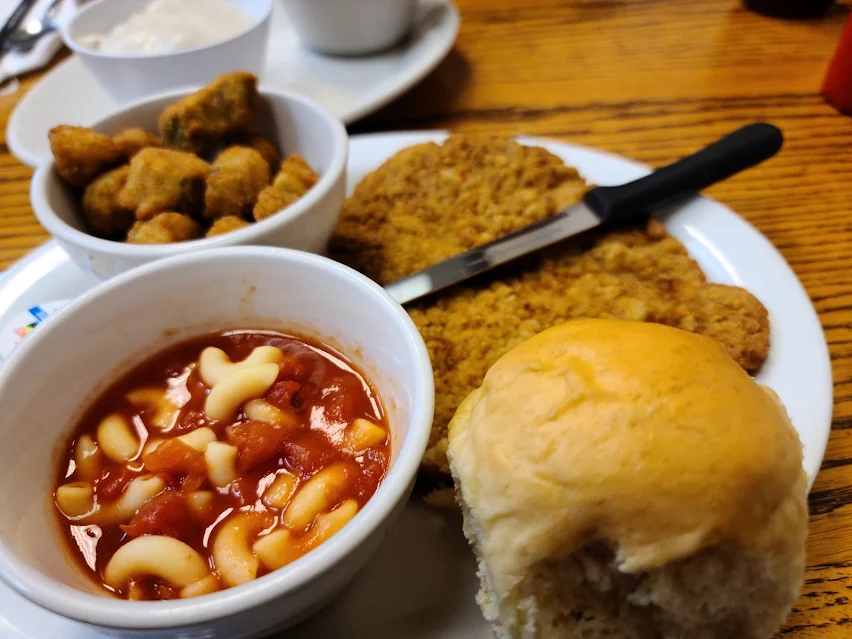 Breaded tenderloin sandwich with shredded cheese, onion rings and fresh toppings at Roxanne's Cafe, Parkville MO