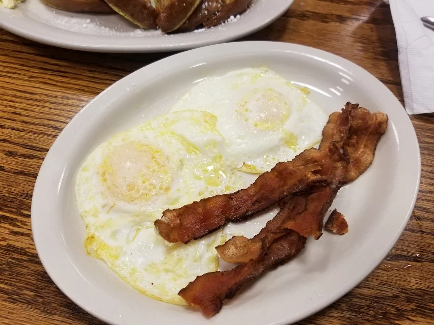Two sunny-side eggs with crispy bacon strips at Roxanne's Cafe in Parkville, Missouri
