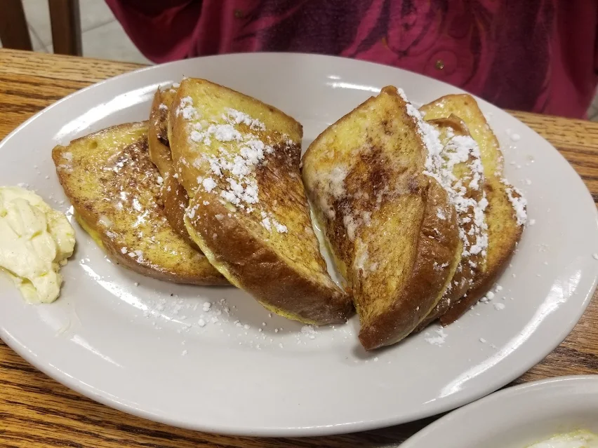 Golden French toast dusted with powdered sugar at Roxanne's Cafe in Parkville, Missouri