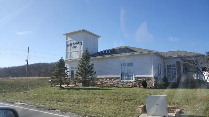Roxanne's Cafe exterior in Parkville, Missouri — the white building with the Roxanne's Cafe sign at Highway 45 and Crooked Road